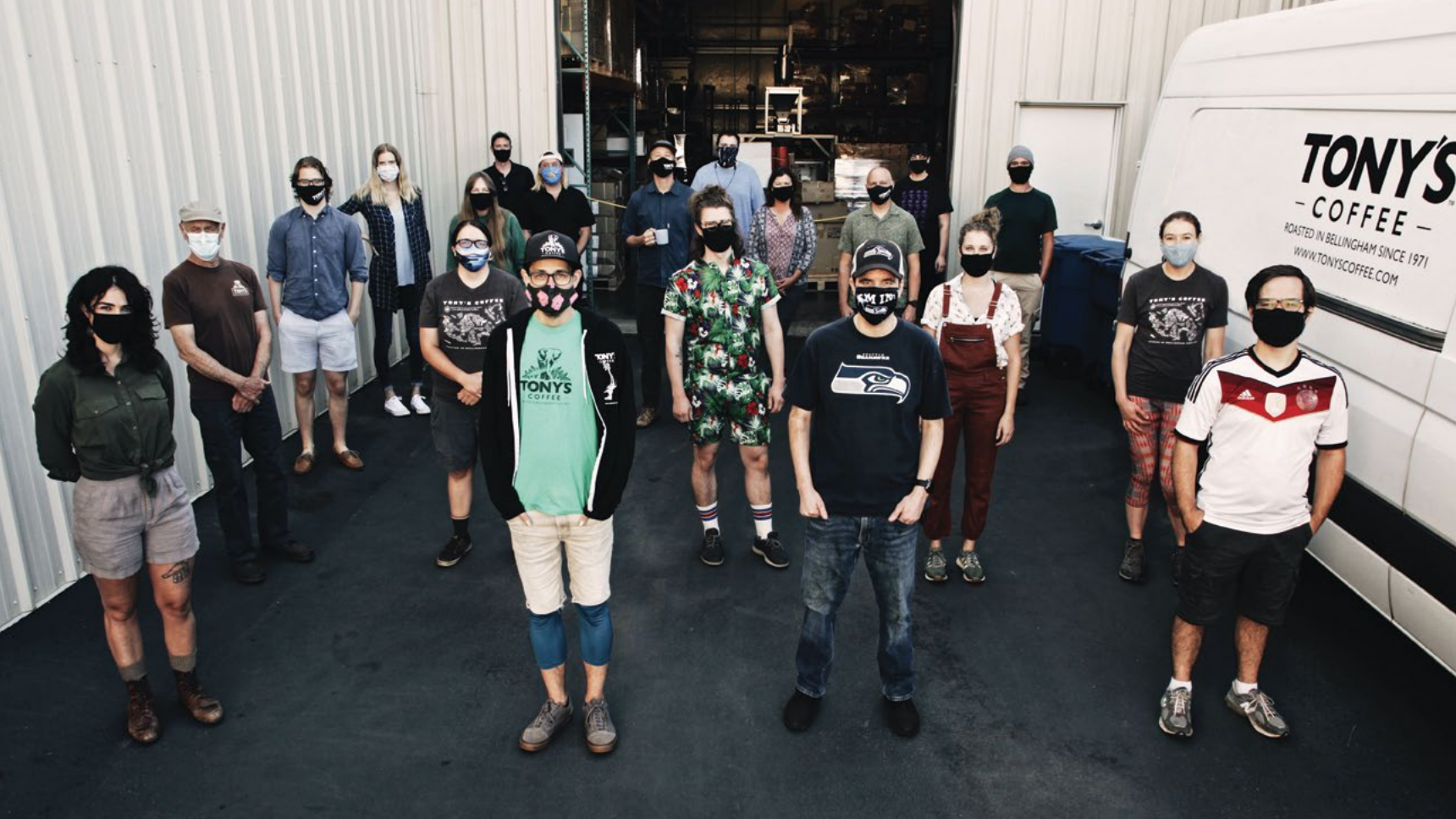 The Tony's Coffee team, wearing masks and standing in front of the warehouse.